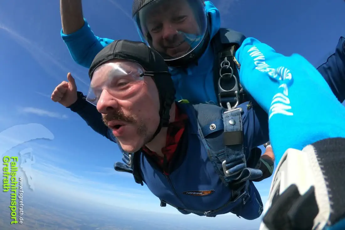 Tandemfallschirmsprung -Freier Fall. Zufriedene Gesichter.